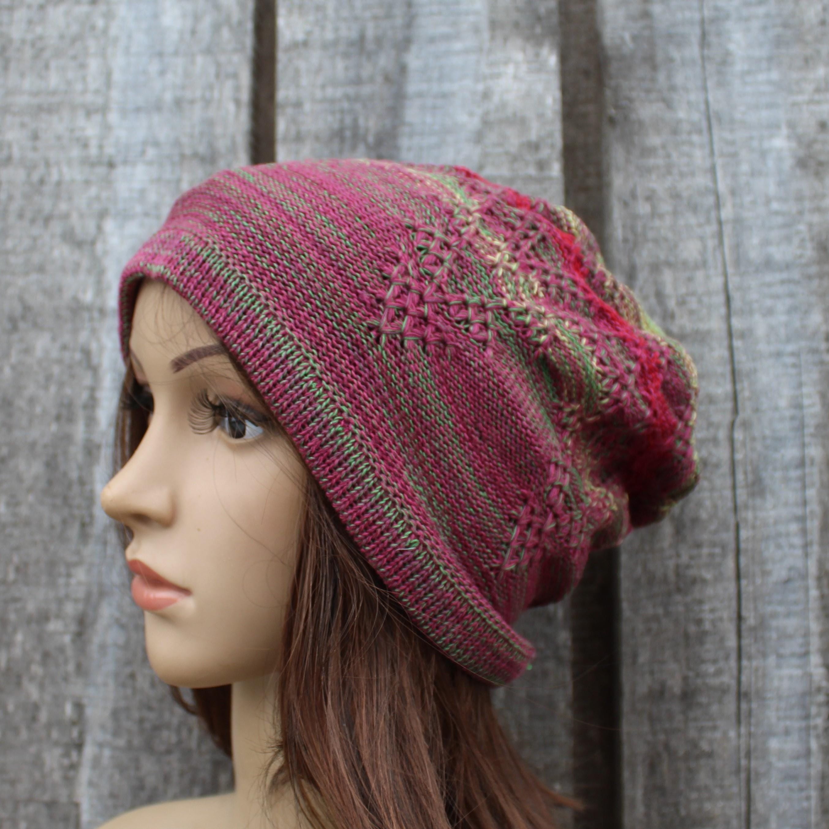 Knitted pink beanie on a mannequin head against a wooden background