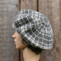Knitted beret on a mannequin head against a wooden background