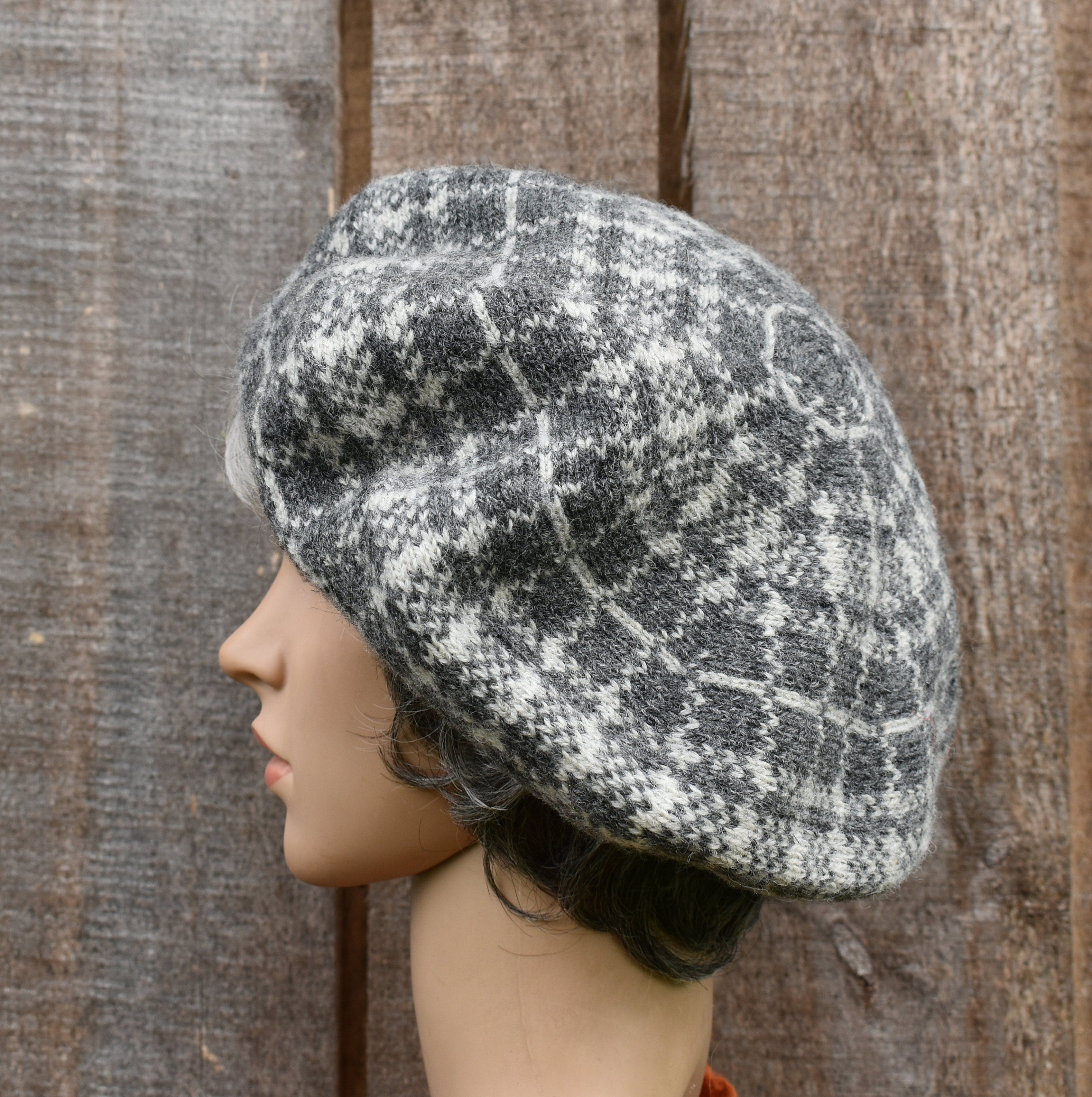 Knitted beret on a mannequin head against a wooden background