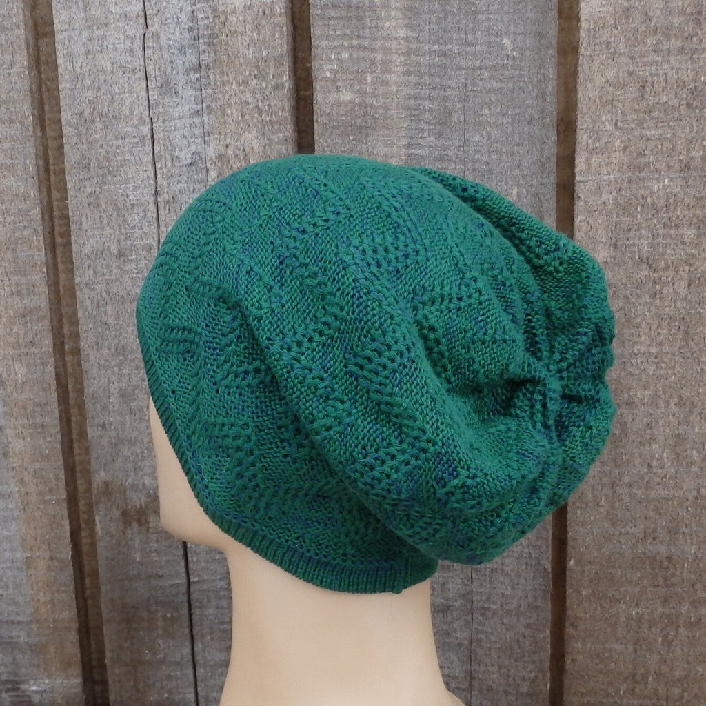 Green knitted beanie on a mannequin head against a wooden background
