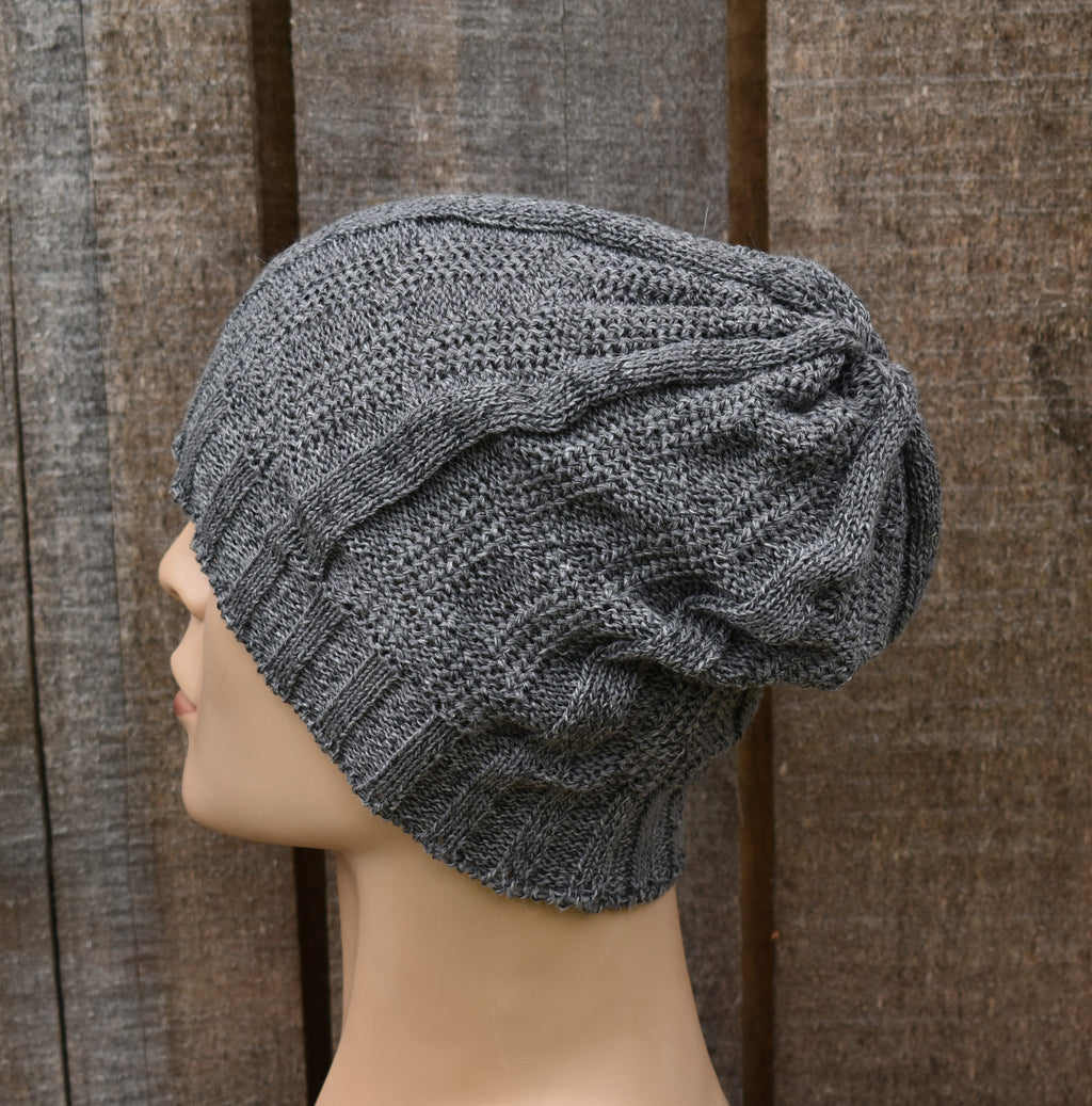 Gray knit turban on a mannequin head against a wooden background