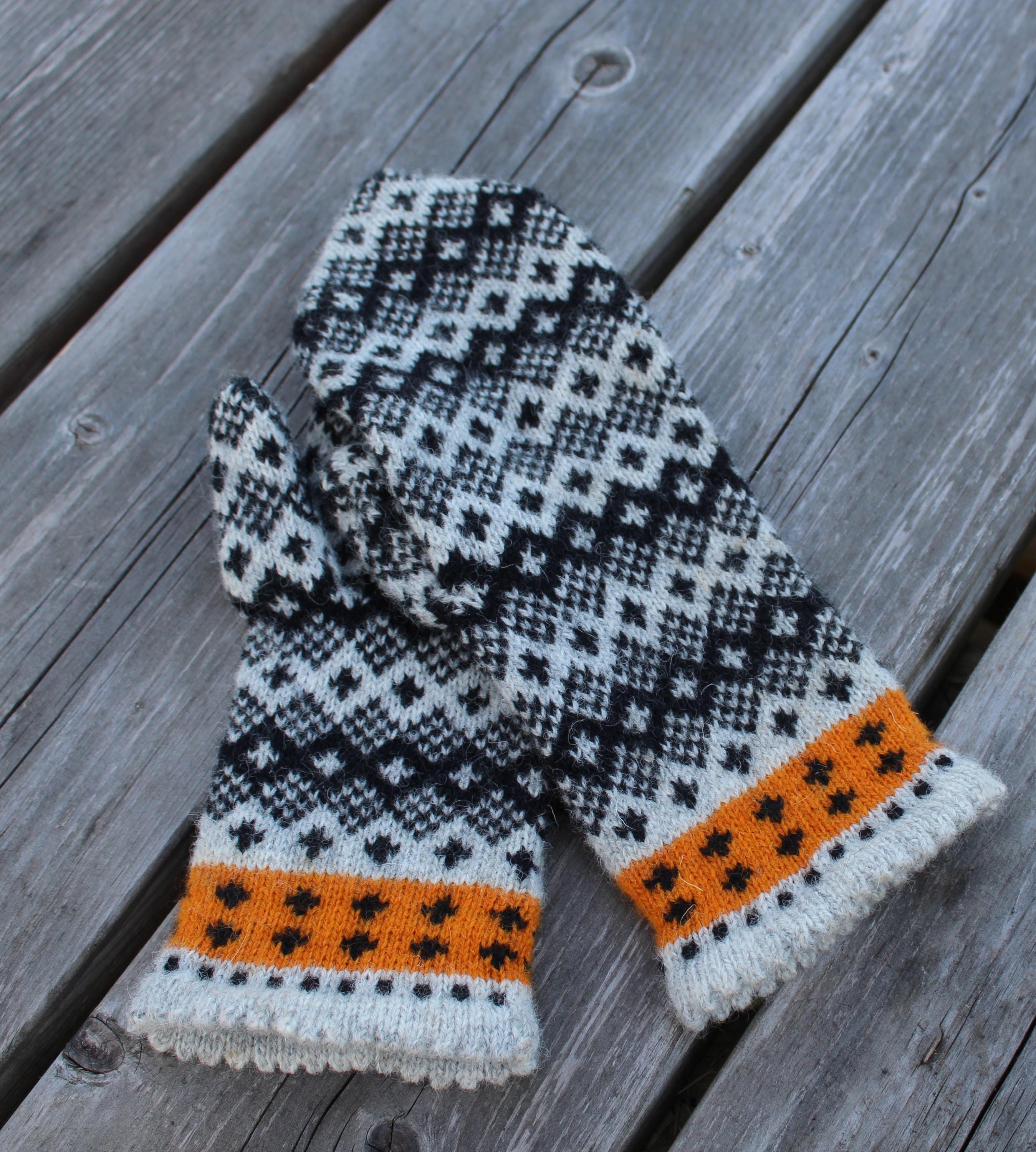 Knitted mittens with a geometric pattern on a wooden surface