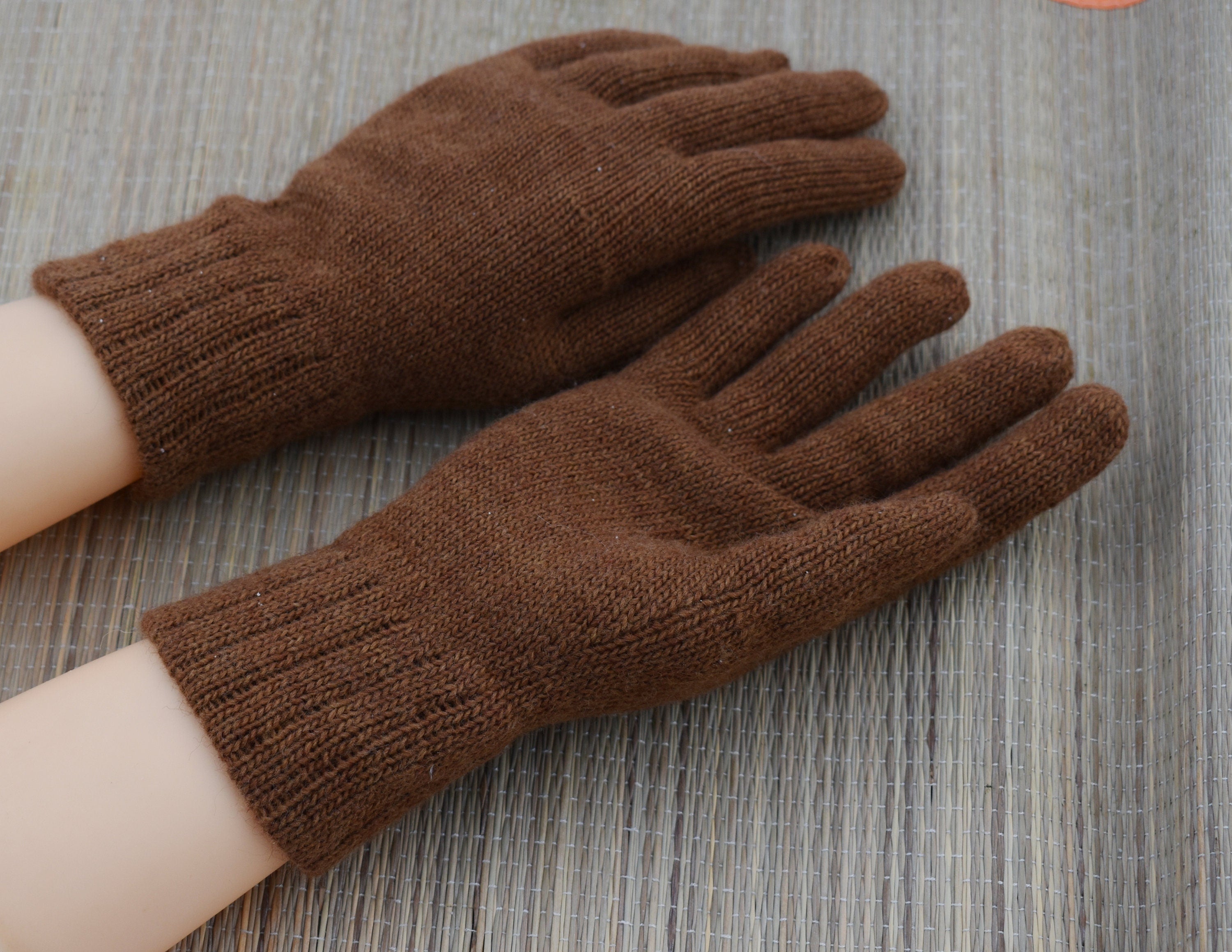 Brown knitted gloves on a wooden surface