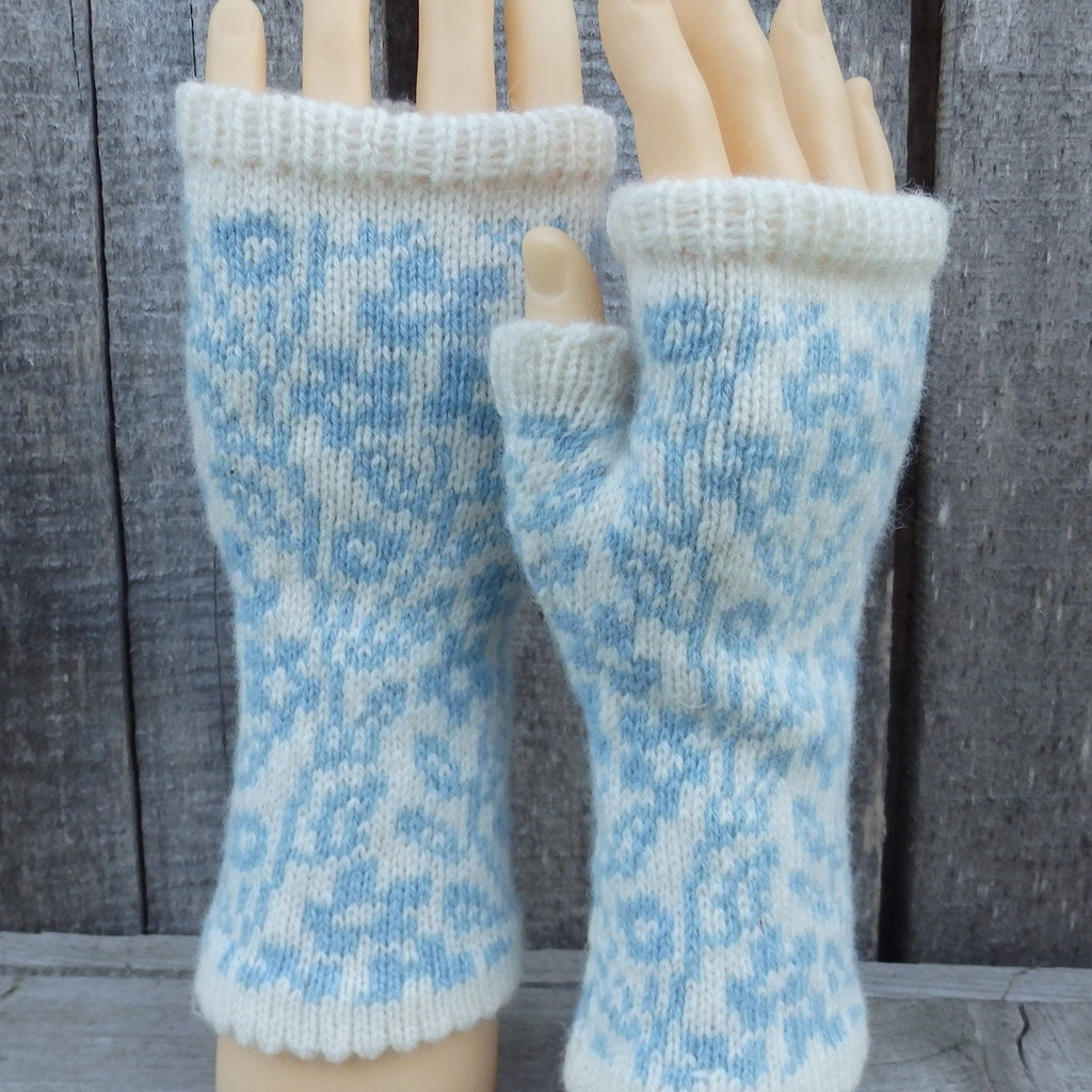 Pair of blue and white patterned fingerless gloves on a wooden mannequin.