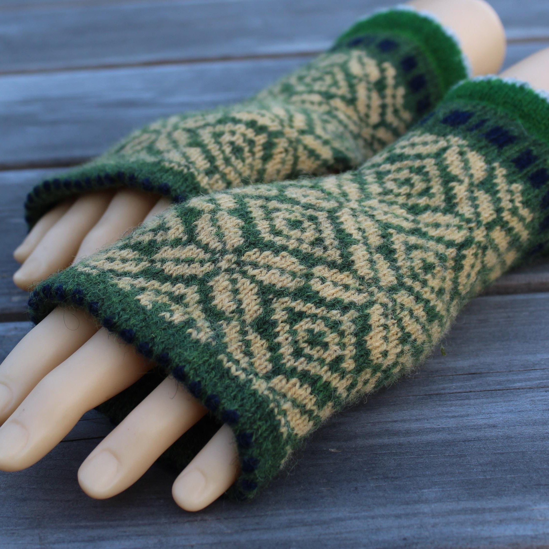 Green and  yellow  Latvian fingerless gloves on a wooden surface