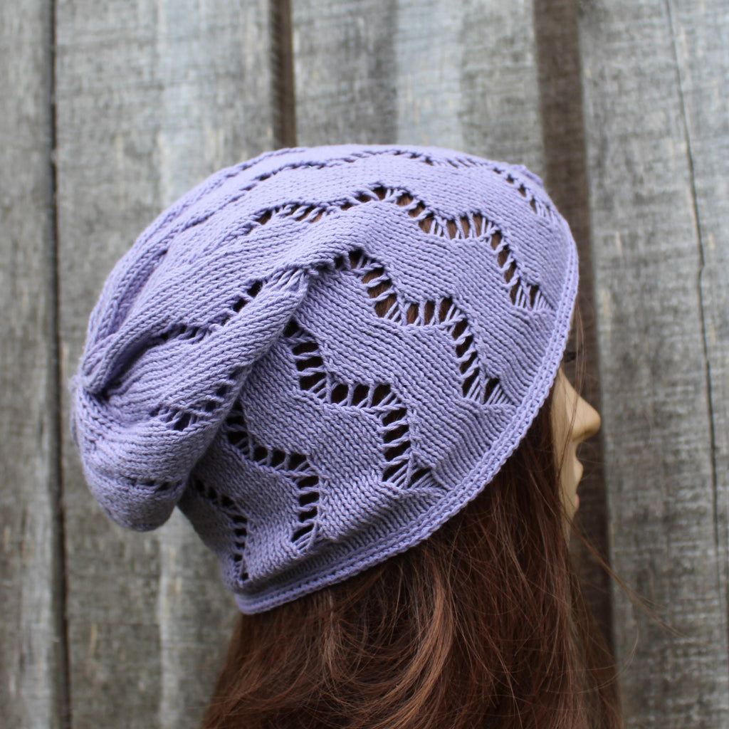 Lavender knitted beanie on a mannequin head against a wooden background