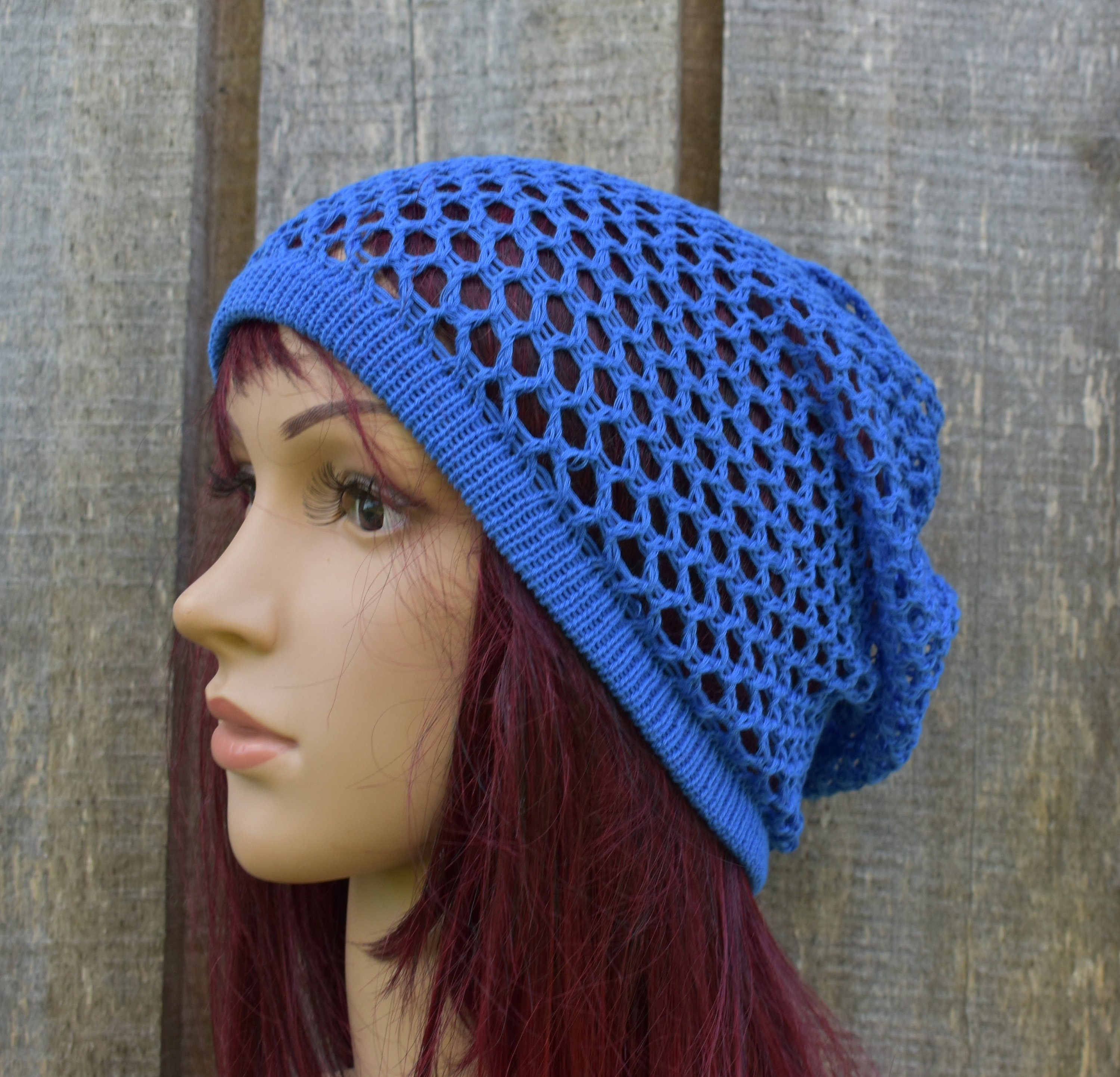 Blue knitted hat on a mannequin head against a wooden background