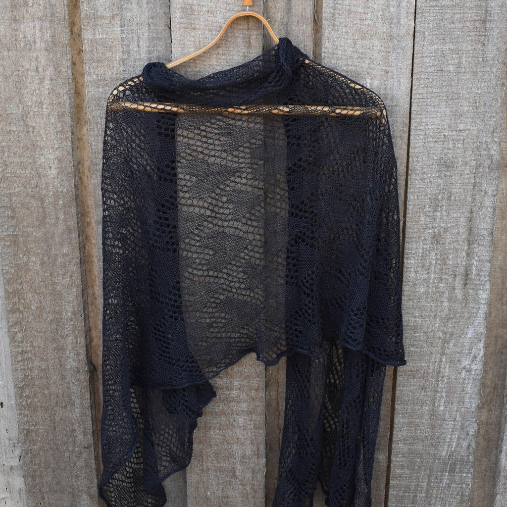 Black lace shawl on a wooden hanger against a wooden background