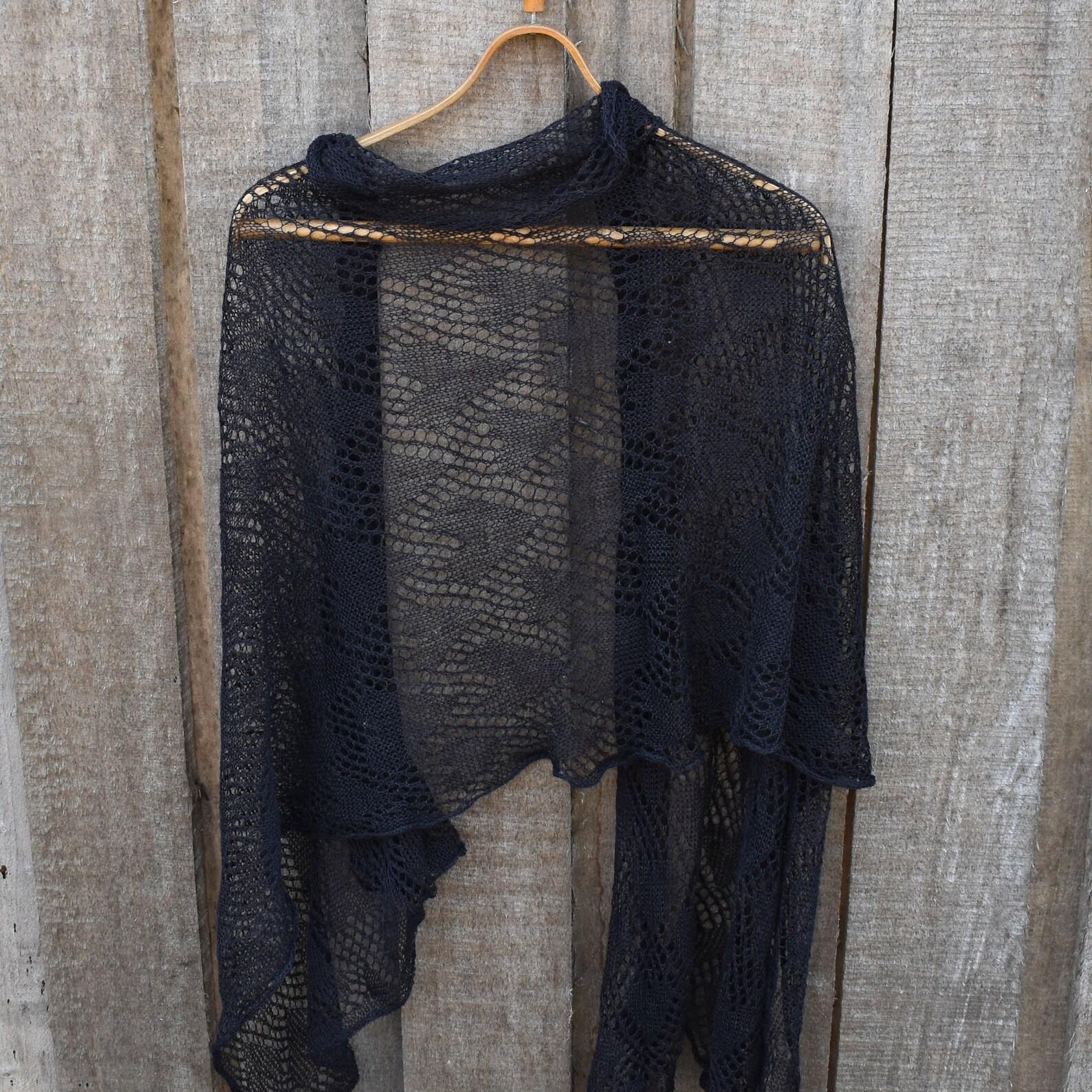 Black lace shawl on a wooden hanger against a wooden background