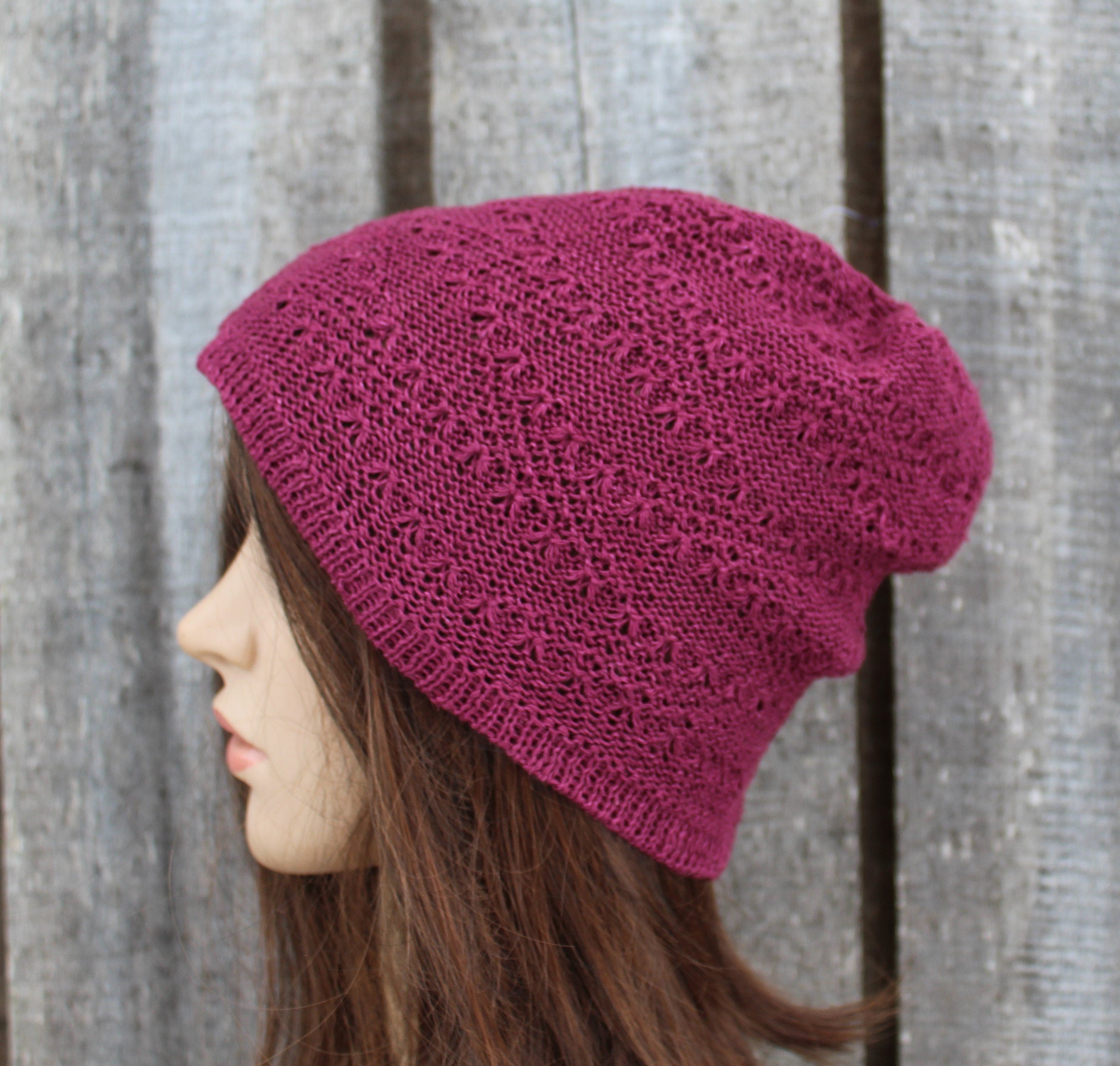 Person wearing a pink knitted beanie against a wooden background