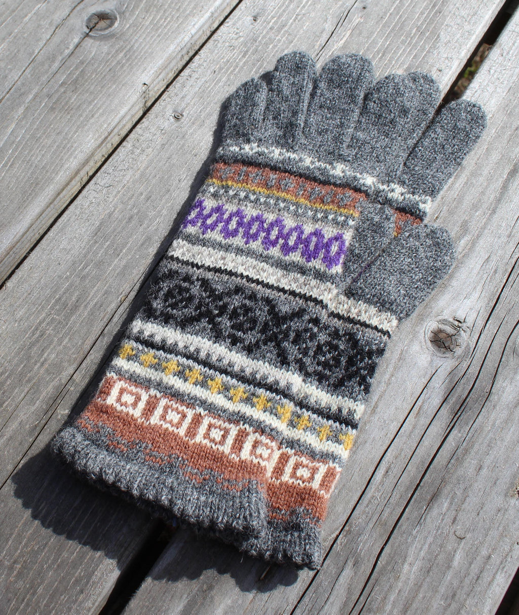 Gray knit glove with colorful pattern on a wooden surface