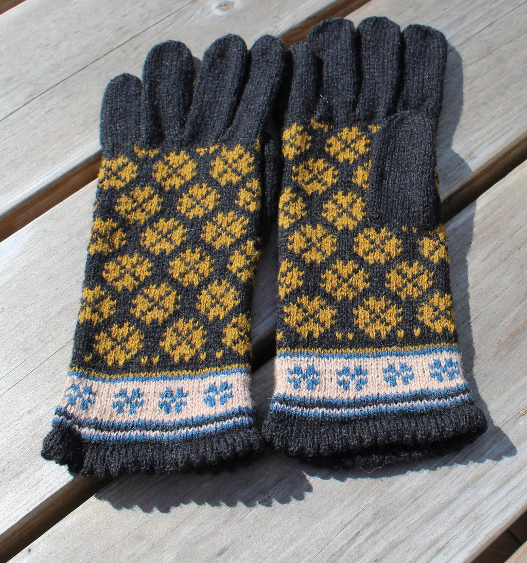 Pair of knitted gloves with a geometric pattern on a wooden surface