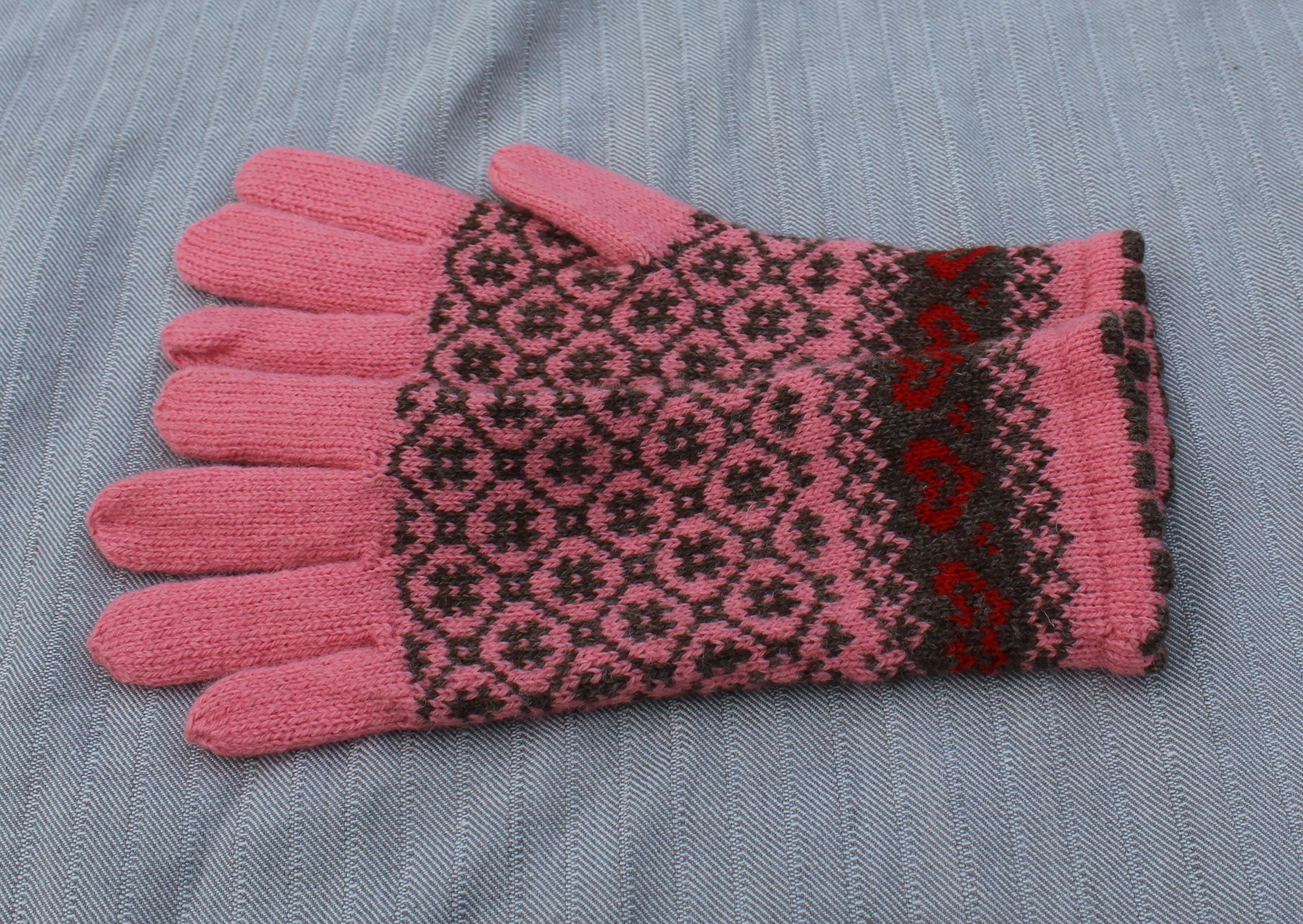 Pink and black patterned glove on a gray fabric background
