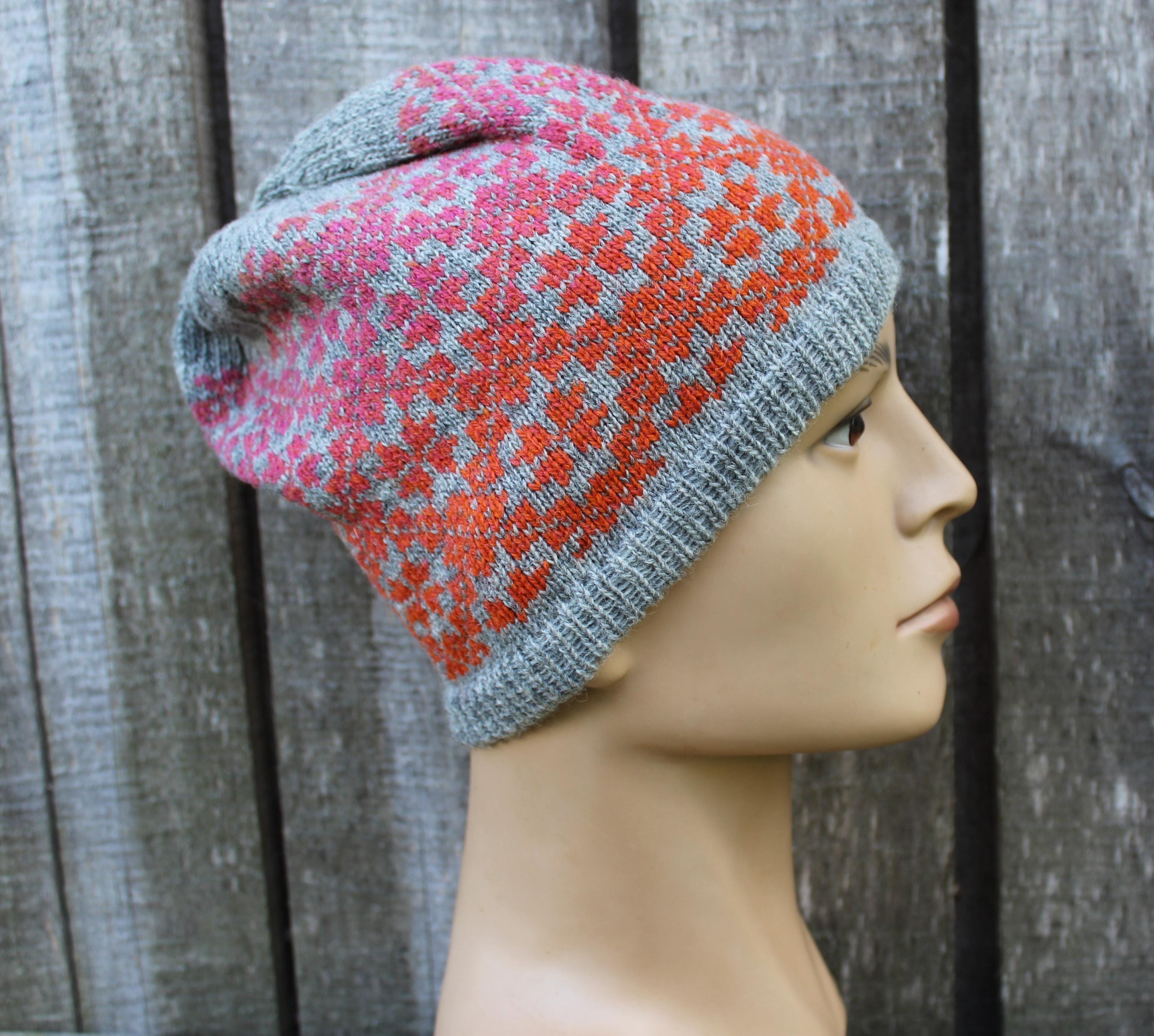 Knitted hat with a pattern on a mannequin head against a wooden background