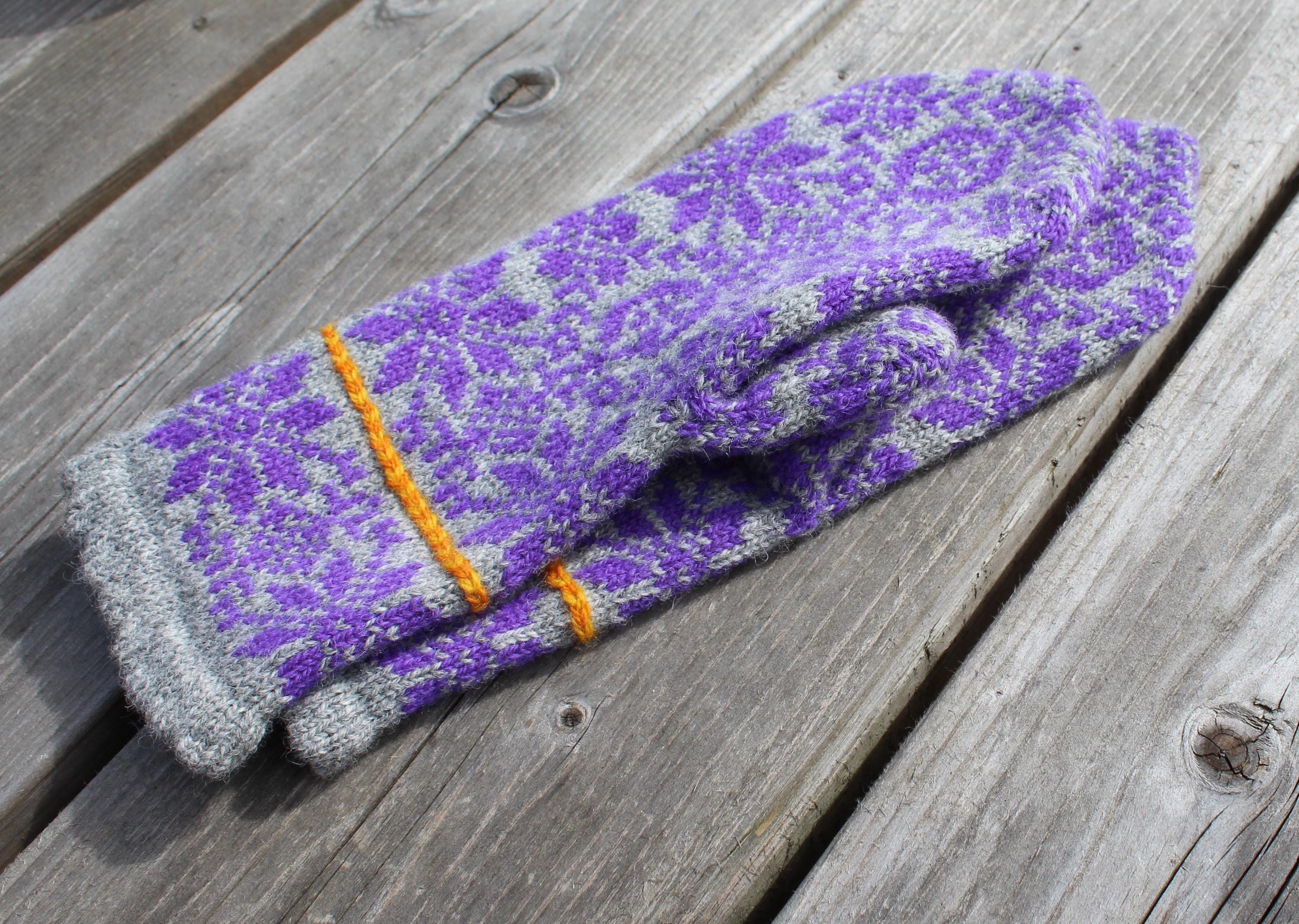 Purple and gray gardening gloves with orange accents on a wooden surface