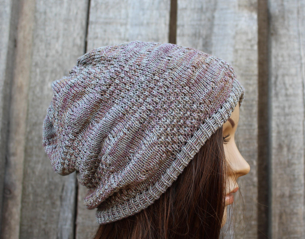 Person wearing a knitted beanie in front of a wooden fence