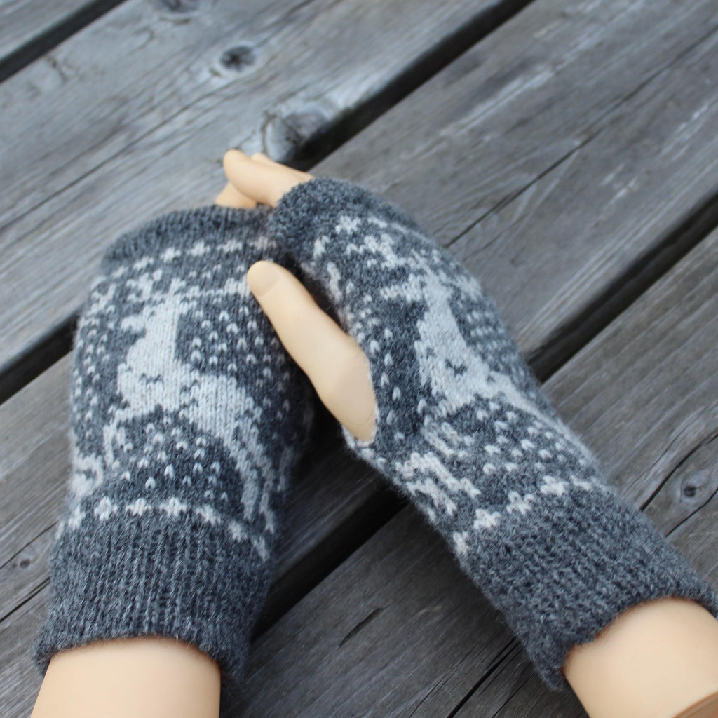 Pair of gray knitted mittens on a wooden surface