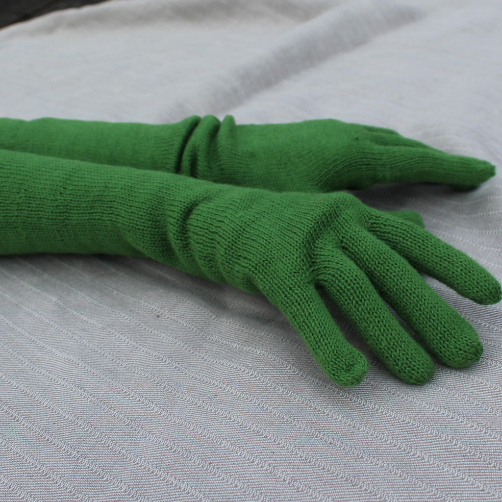 Green gloves on a light gray surface