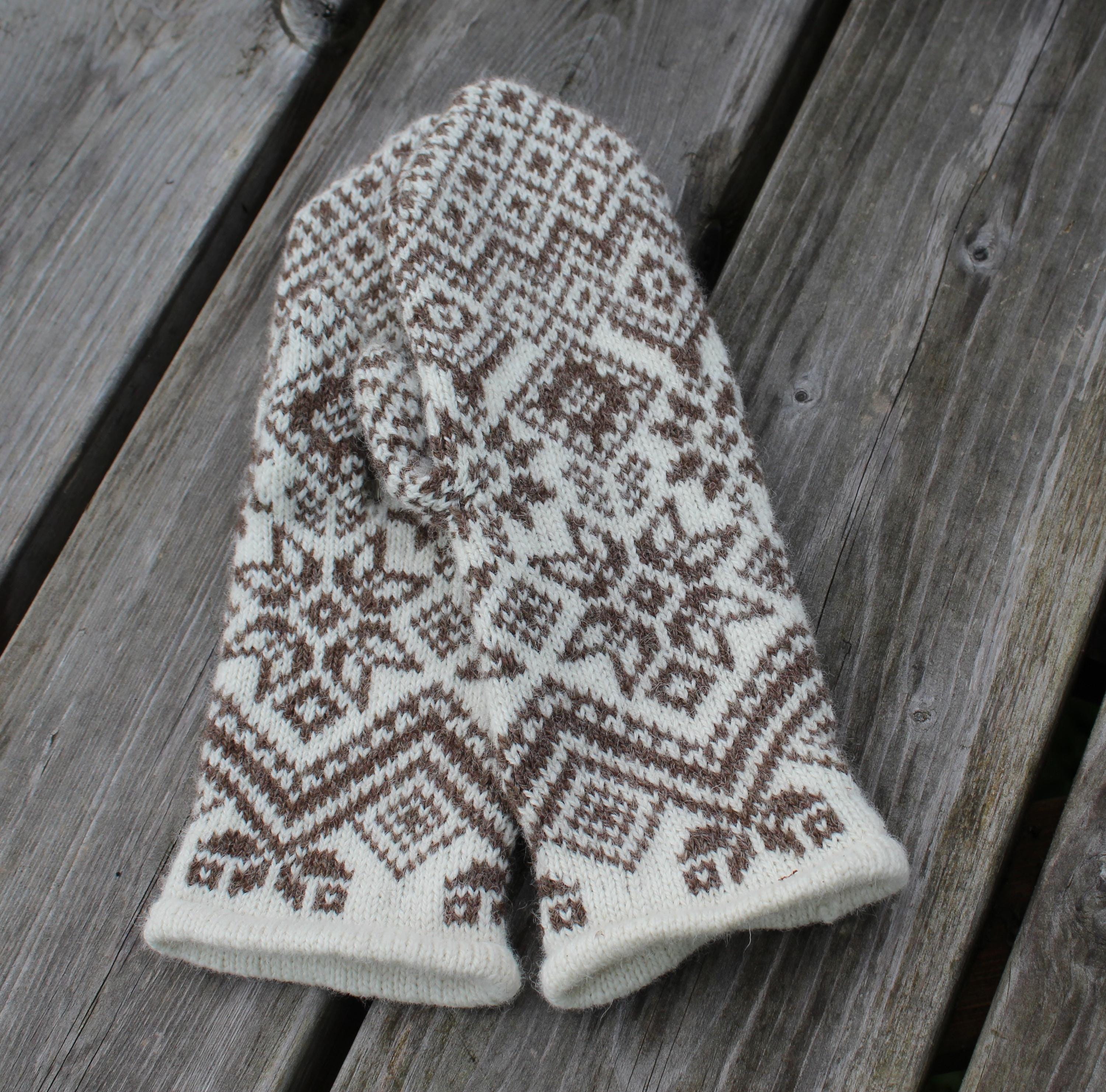 Knitted mitten with a pattern on a wooden surface