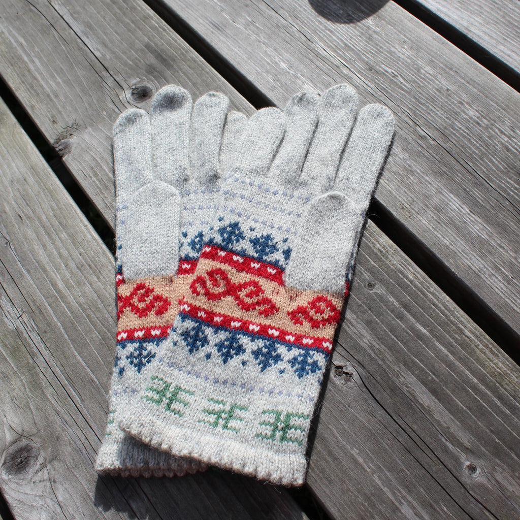 Pair of gray gloves with a colorful pattern on a wooden surface