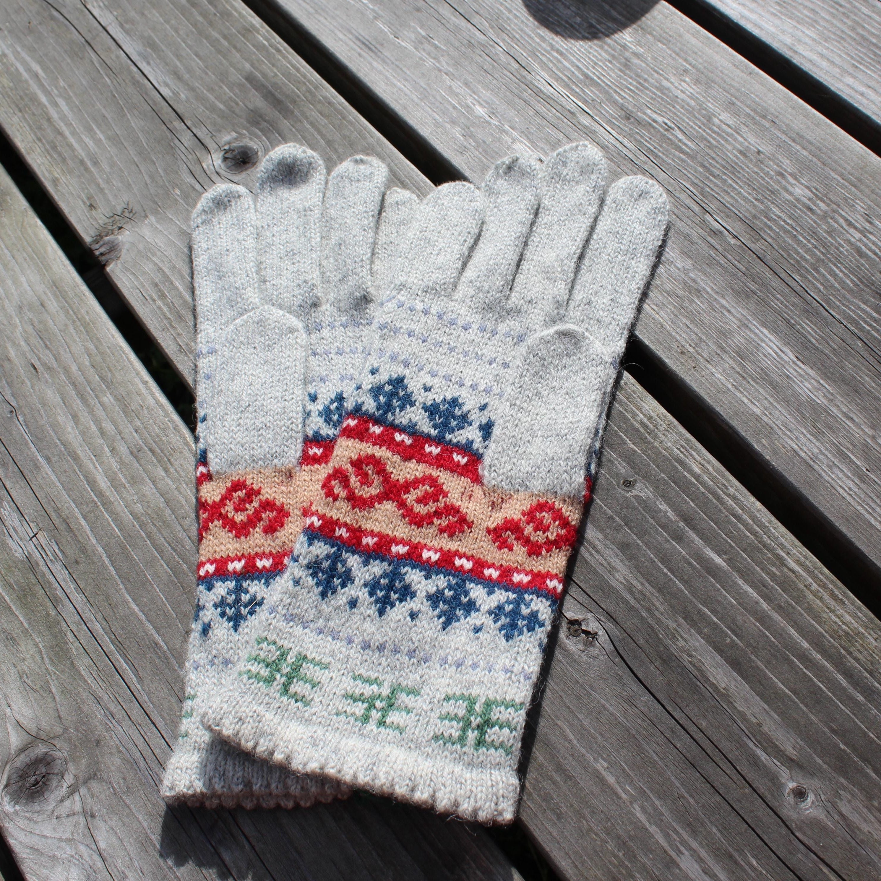 Pair of gray gloves with a colorful pattern on a wooden surface