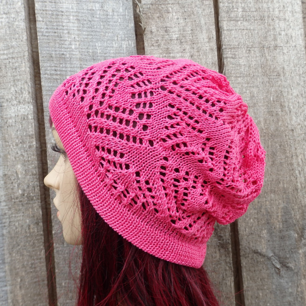 Pink knitted hat worn by a person against a wooden background
