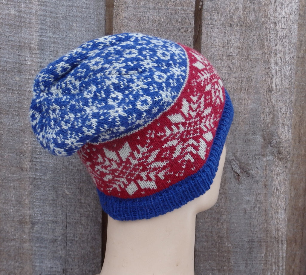 Knitted hat with blue and red pattern on a wooden background