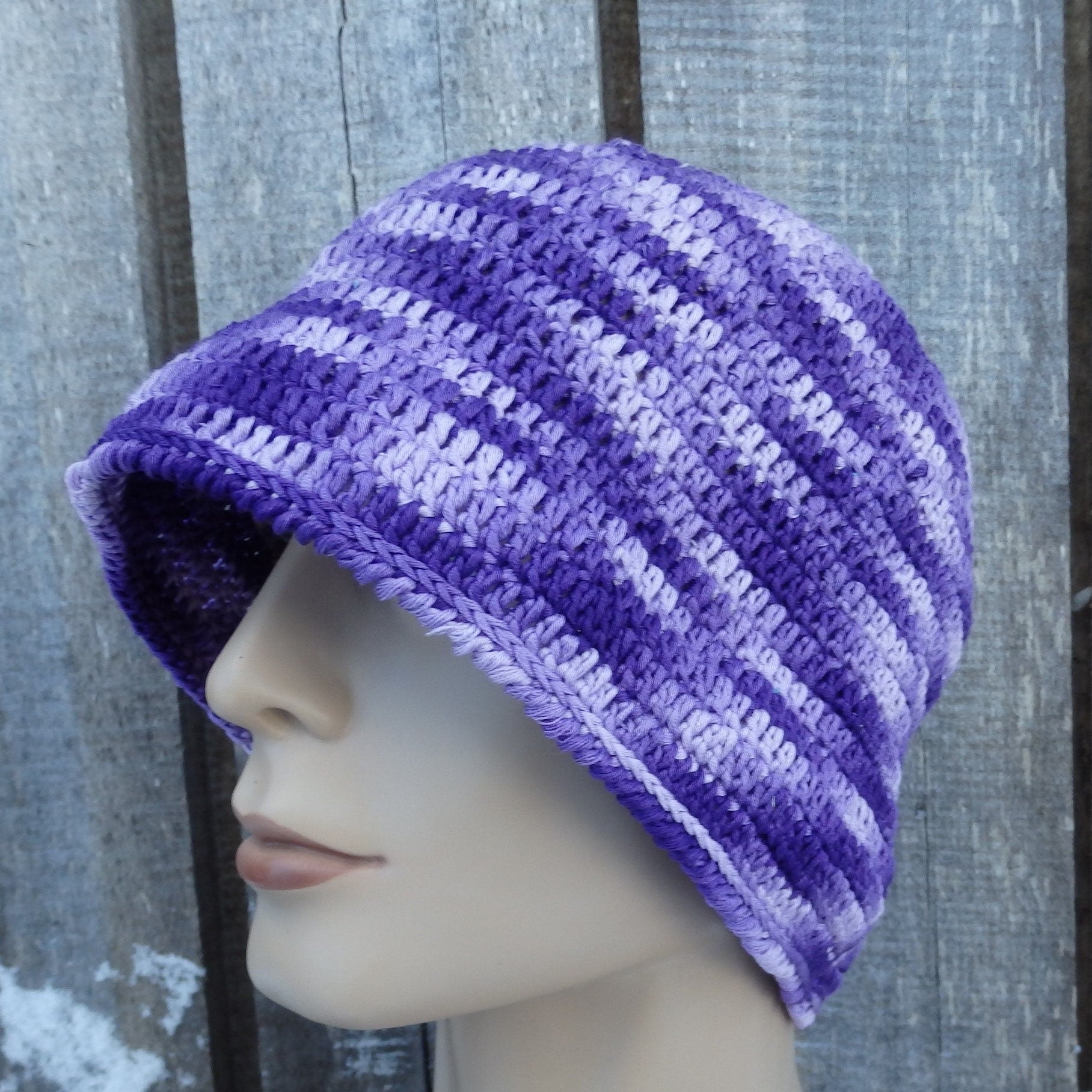 Purple panama hat on a mannequin head against a wooden background