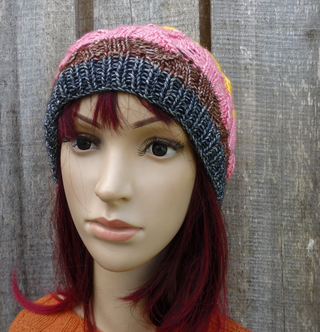 Multicolored knit beanie on a mannequin head against a wooden background