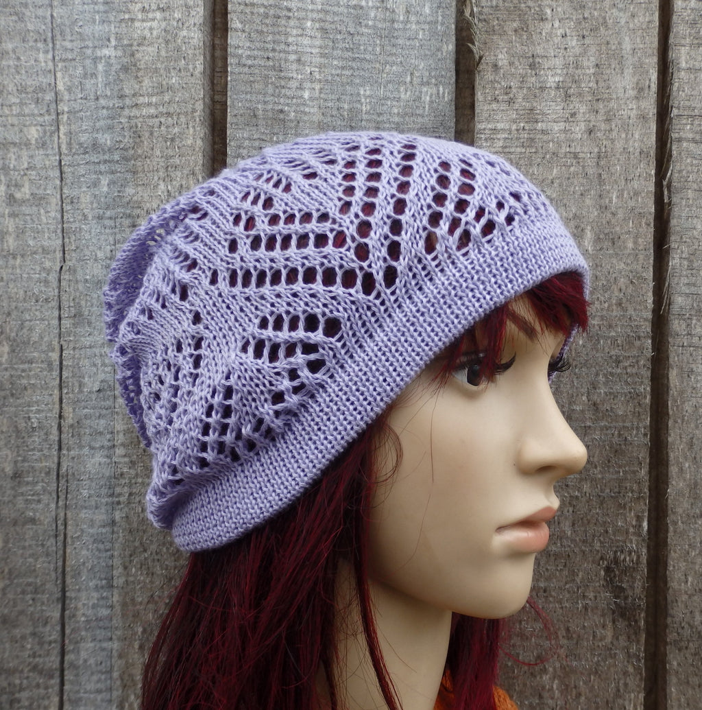 Mannequin head wearing a purple knitted hat against a wooden background