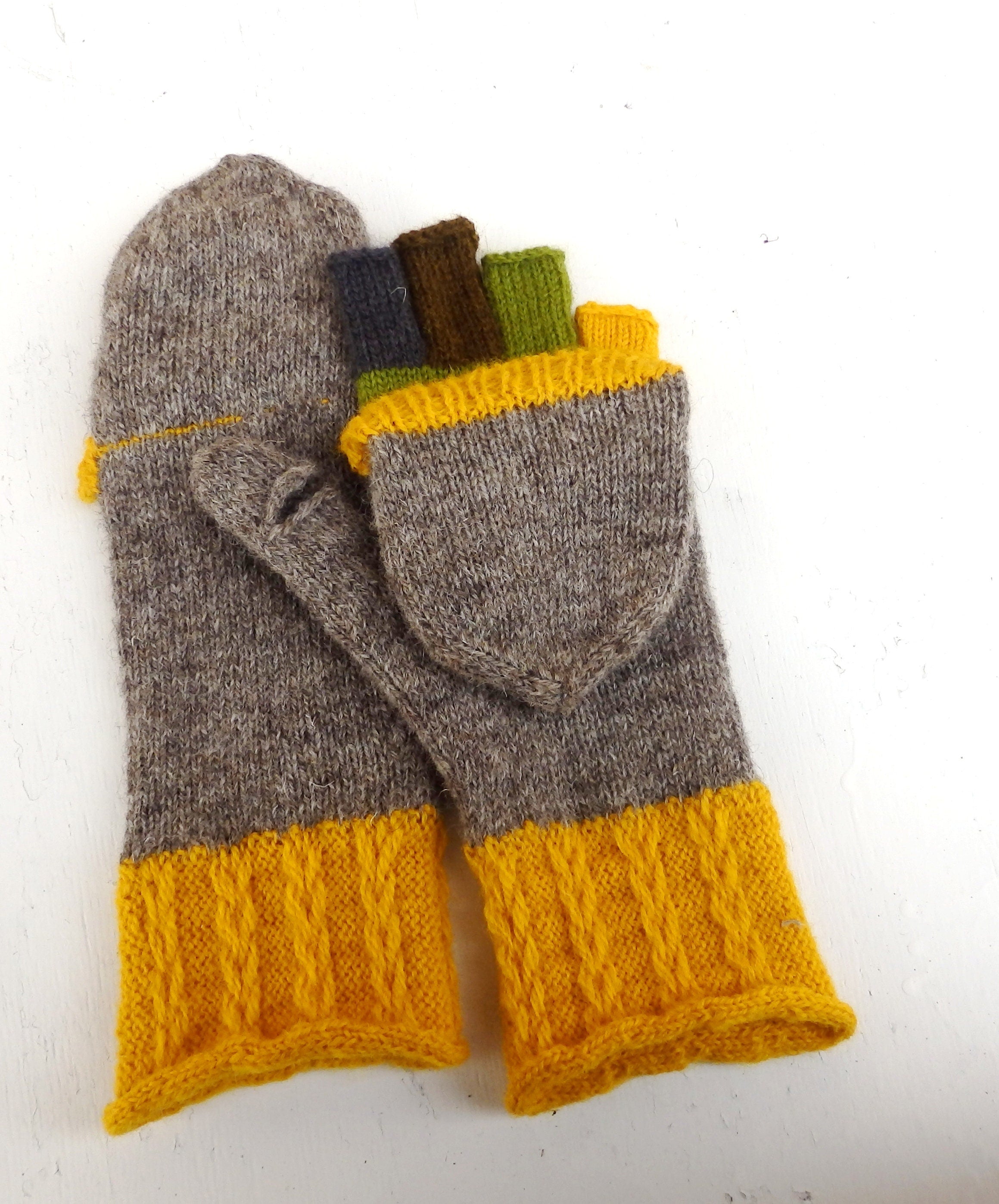 Pair of gray and yellow knit mittens on a white background