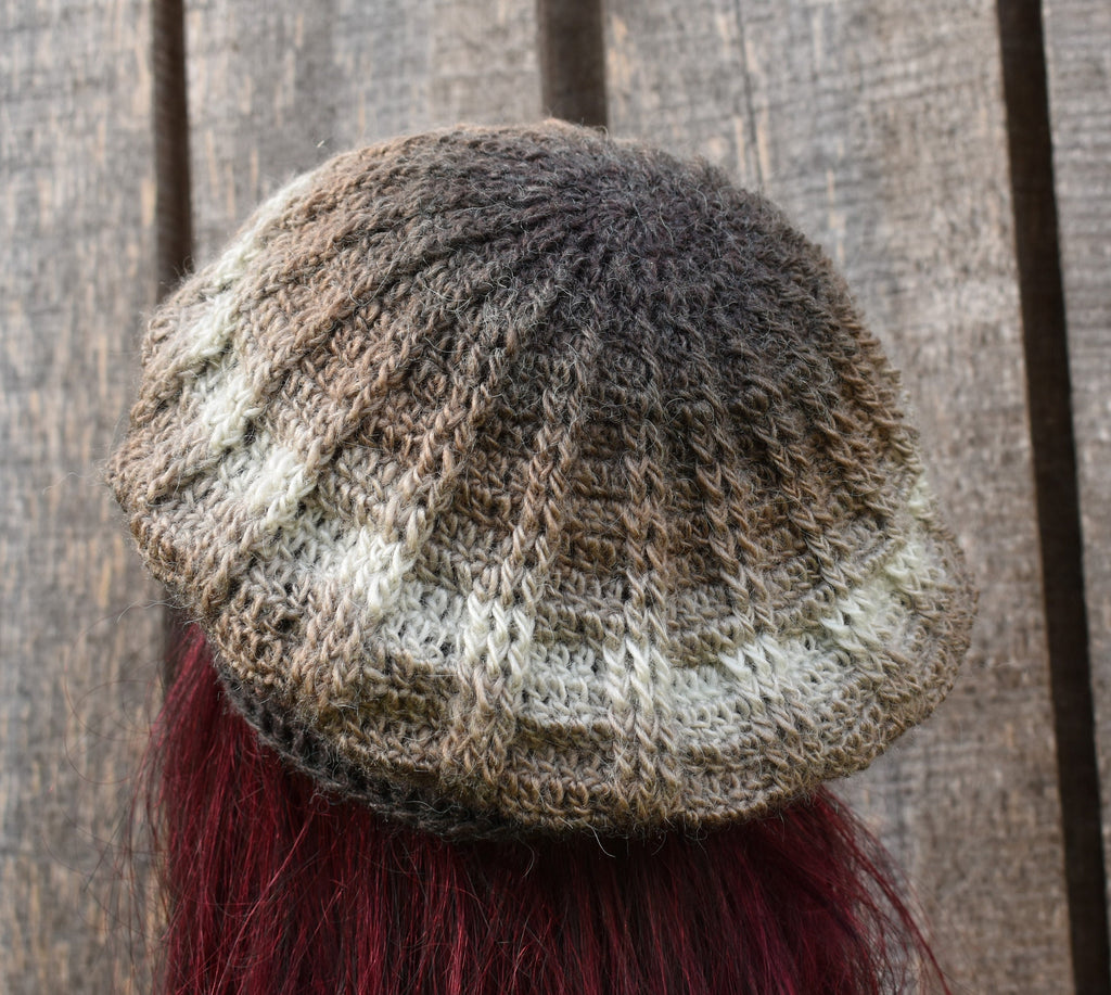 Knitted beanie with gradient colors on a wooden background