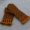 Pair of brown and orange patterned mittens on a gray fabric background