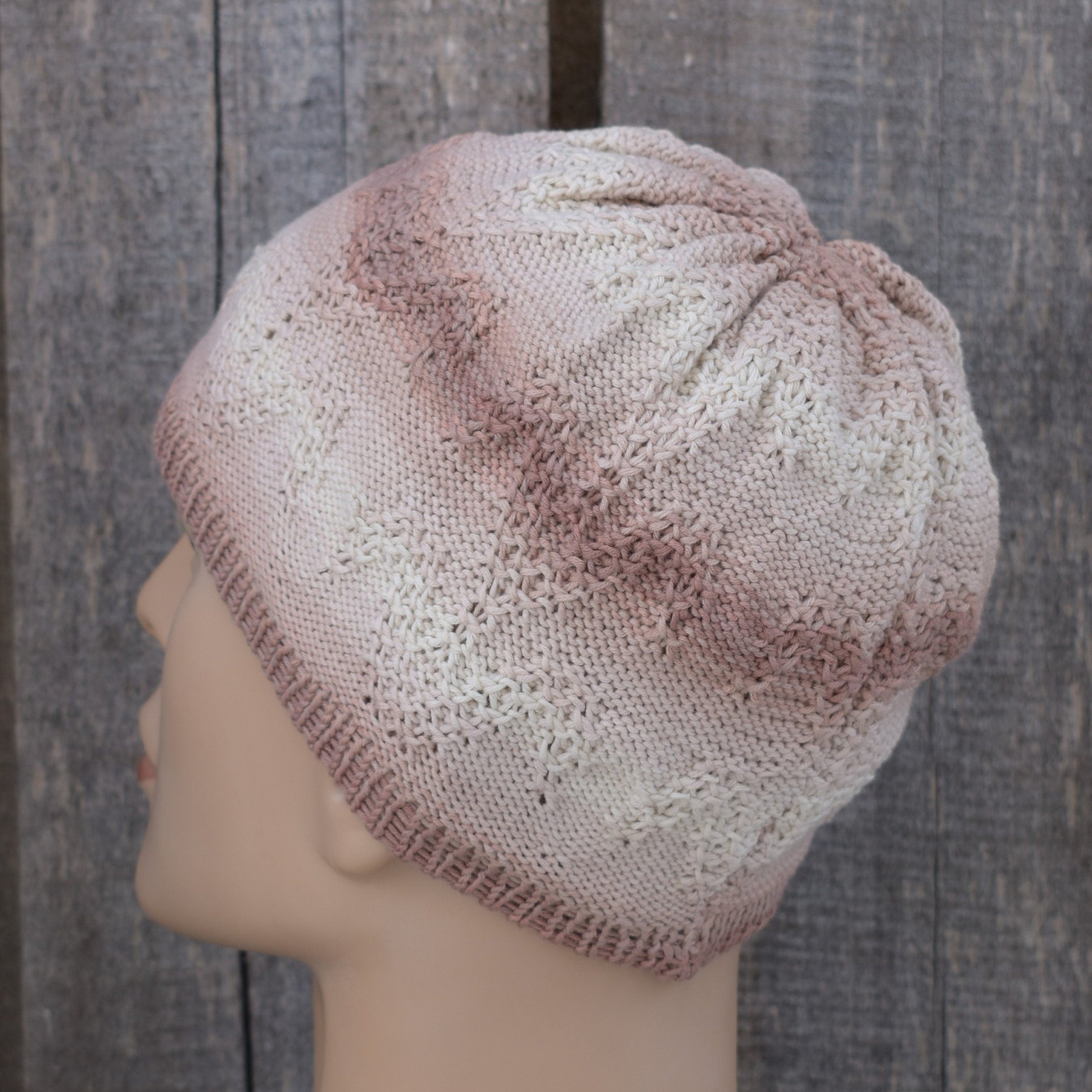 Knitted hat on a mannequin head against a wooden background