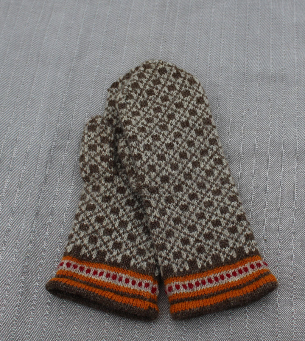Pair of patterned mittens on a textured fabric background