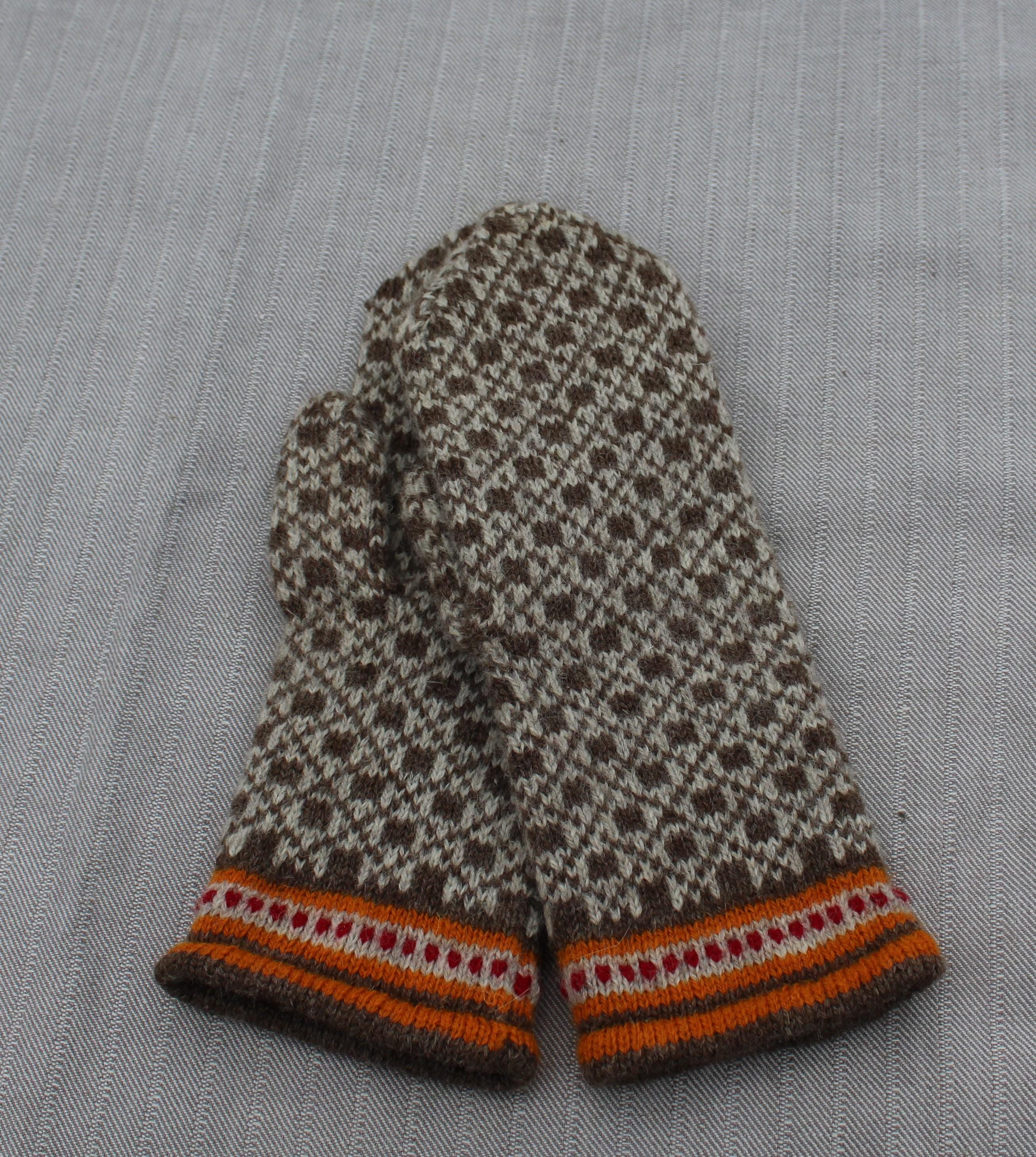 Pair of patterned mittens on a textured fabric background