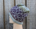 Knitted hat with a floral pattern on a mannequin head against a wooden background