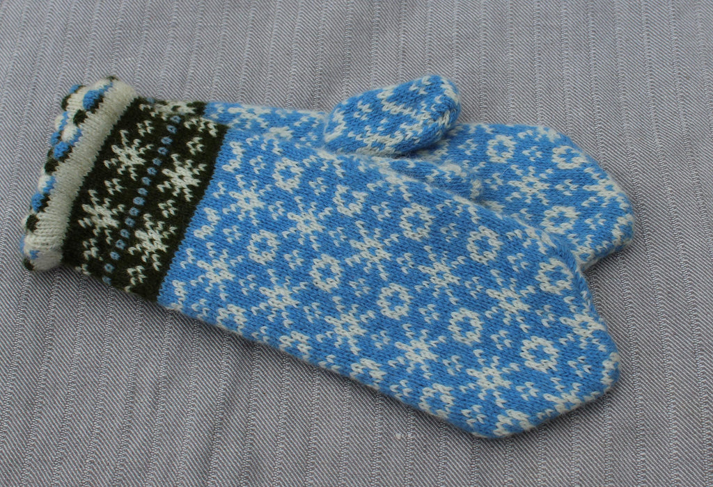 Blue knitted glove with white snowflake pattern on a gray background