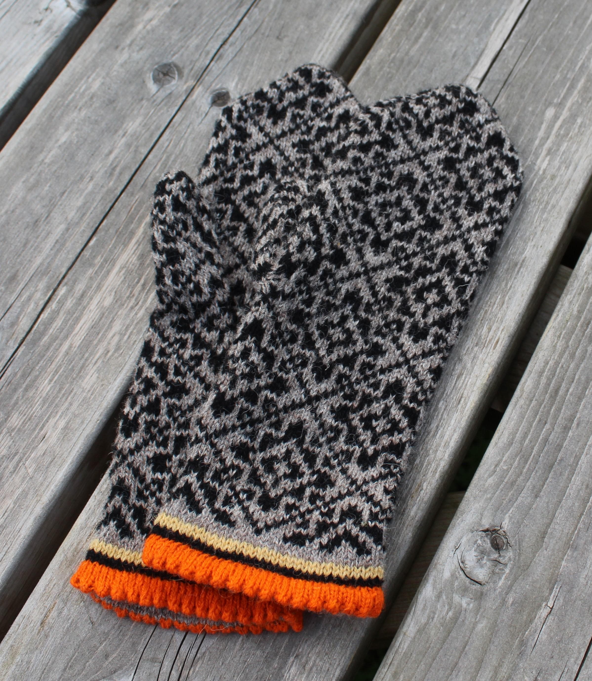 Knitted mitten with a pattern on a wooden surface