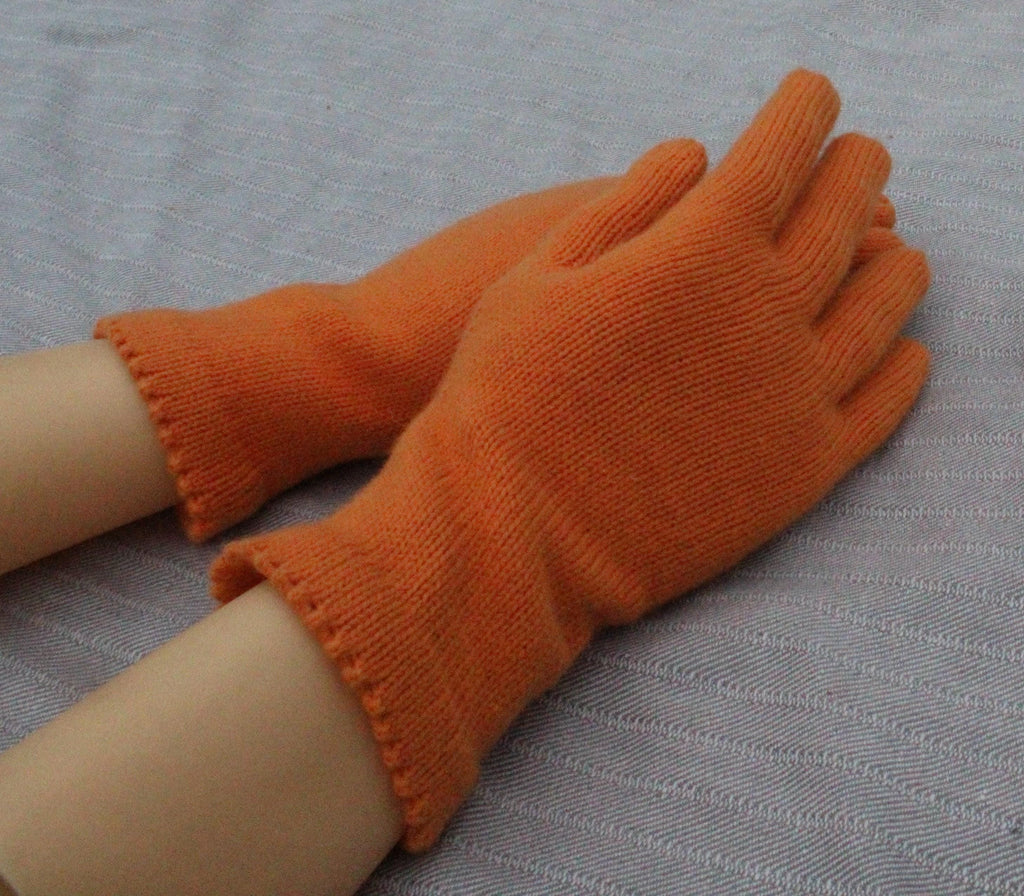 Orange gloves on a person's hands with a gray background