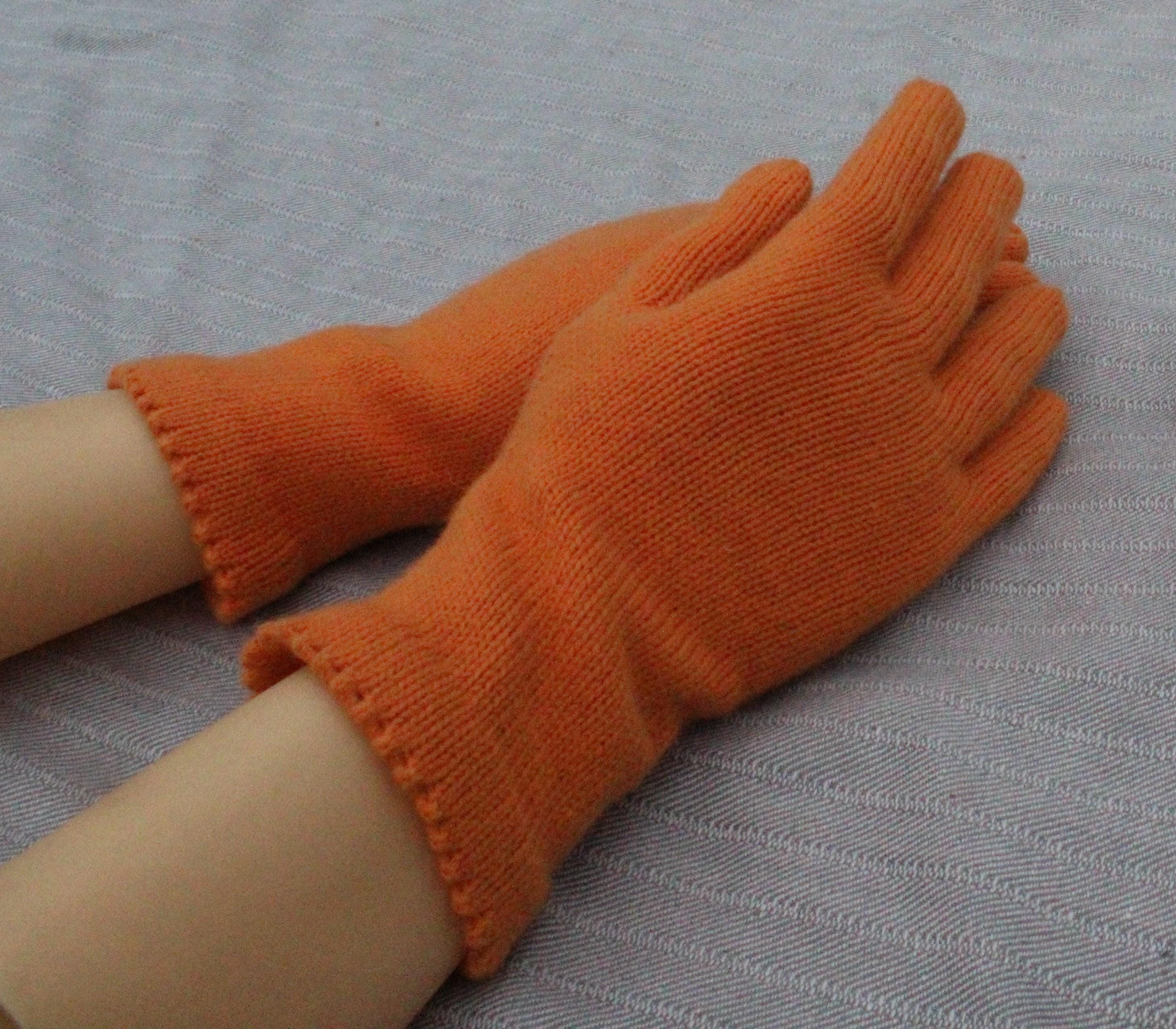 Orange gloves on a person's hands with a gray background