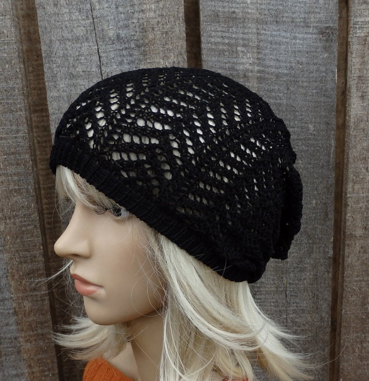 Black knit beanie on a mannequin head against a wooden background