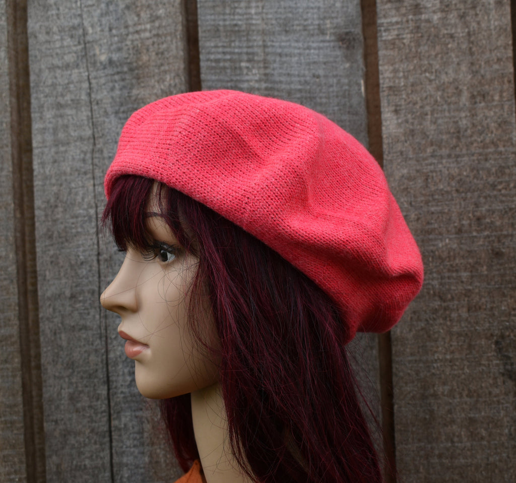 pink knitted beret on a mannequin head against a wooden background