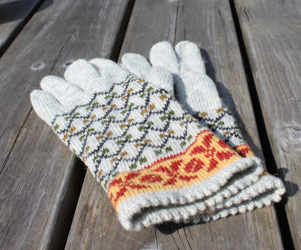 Pair of knitted gloves with a pattern on a wooden surface