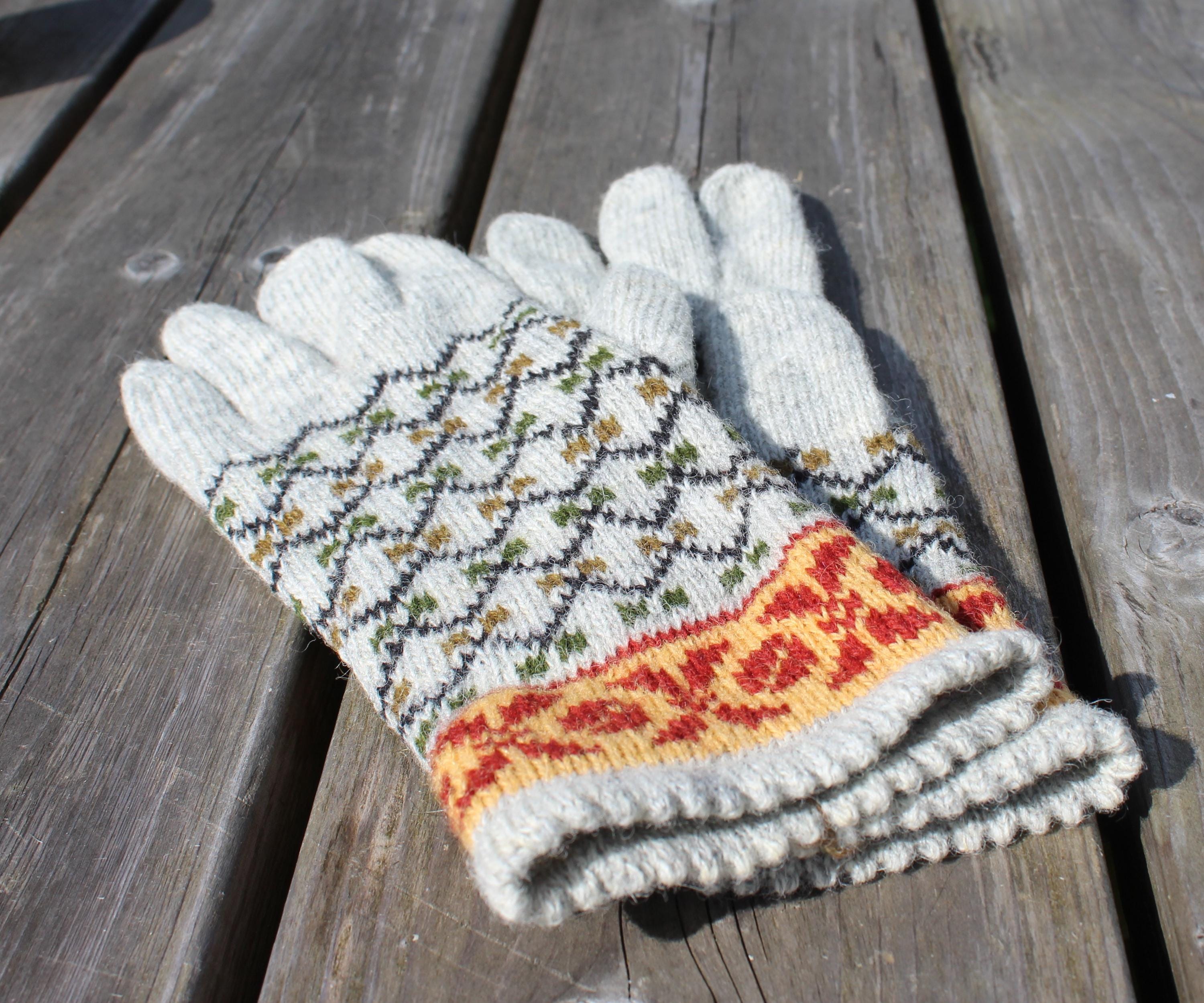 Pair of knitted gloves with a pattern on a wooden surface