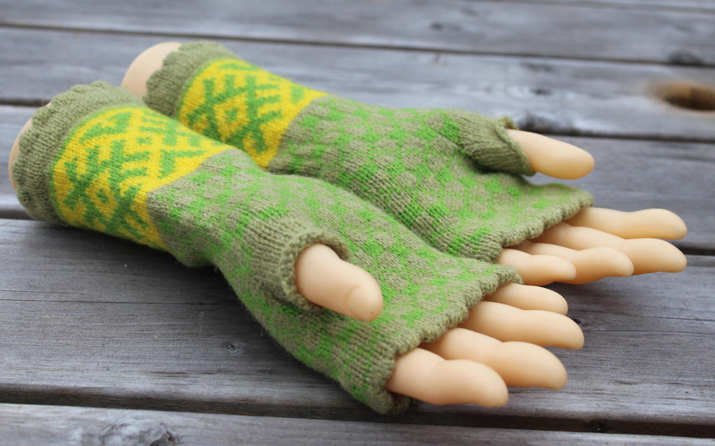 Green and yellow patterned fingerless gloves with beige claws on a wooden surface
