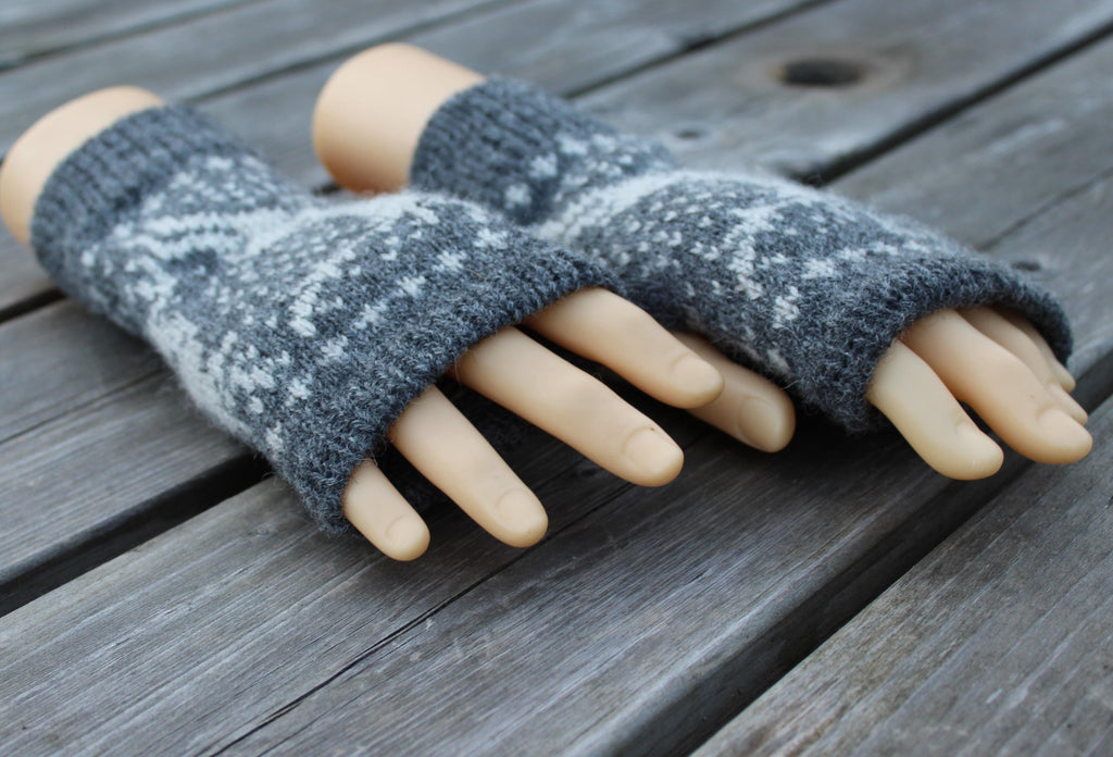 Gray fingerless gloves with white pattern on a wooden surface