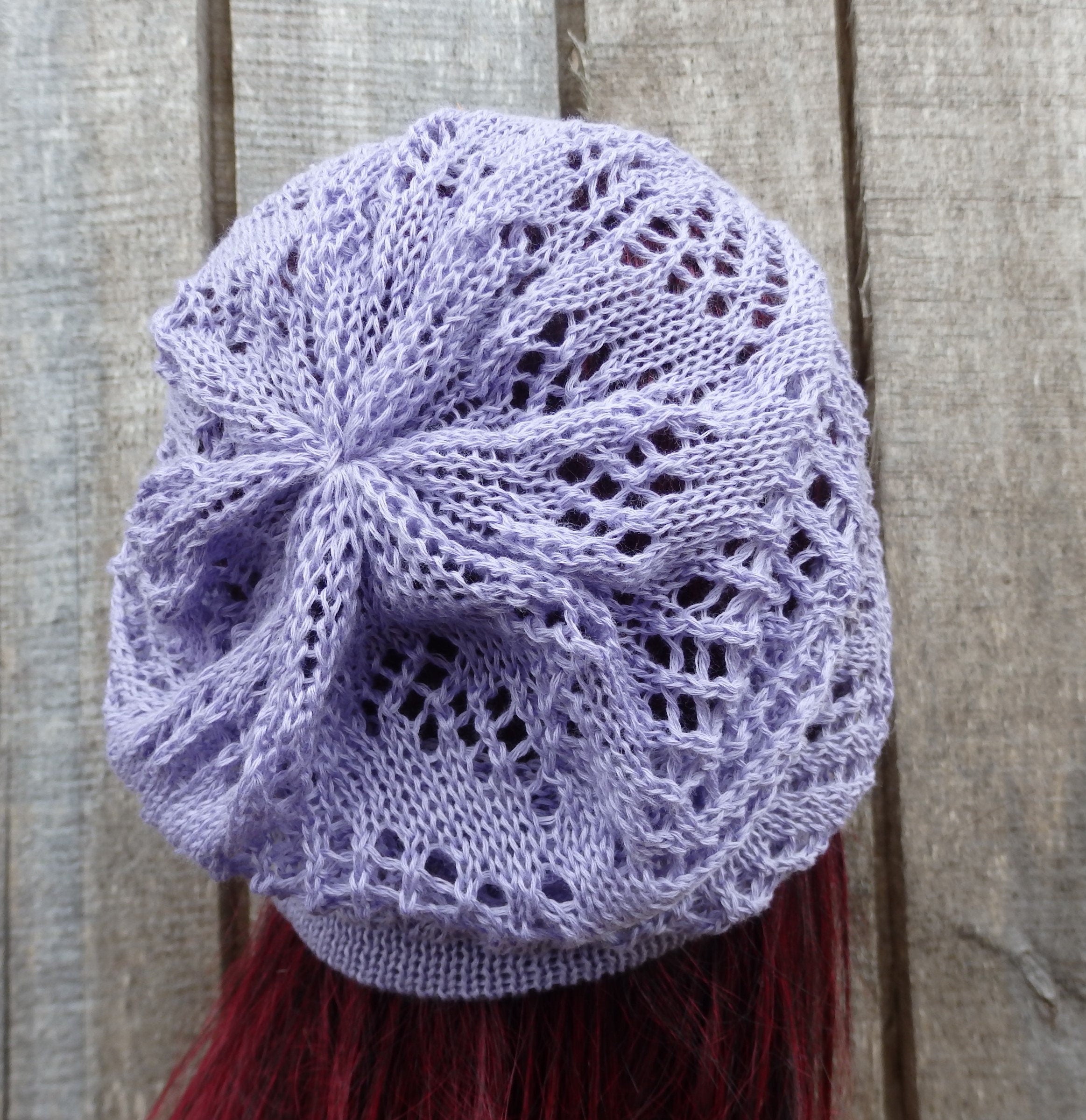 Lace knit purple beanie on a wooden background