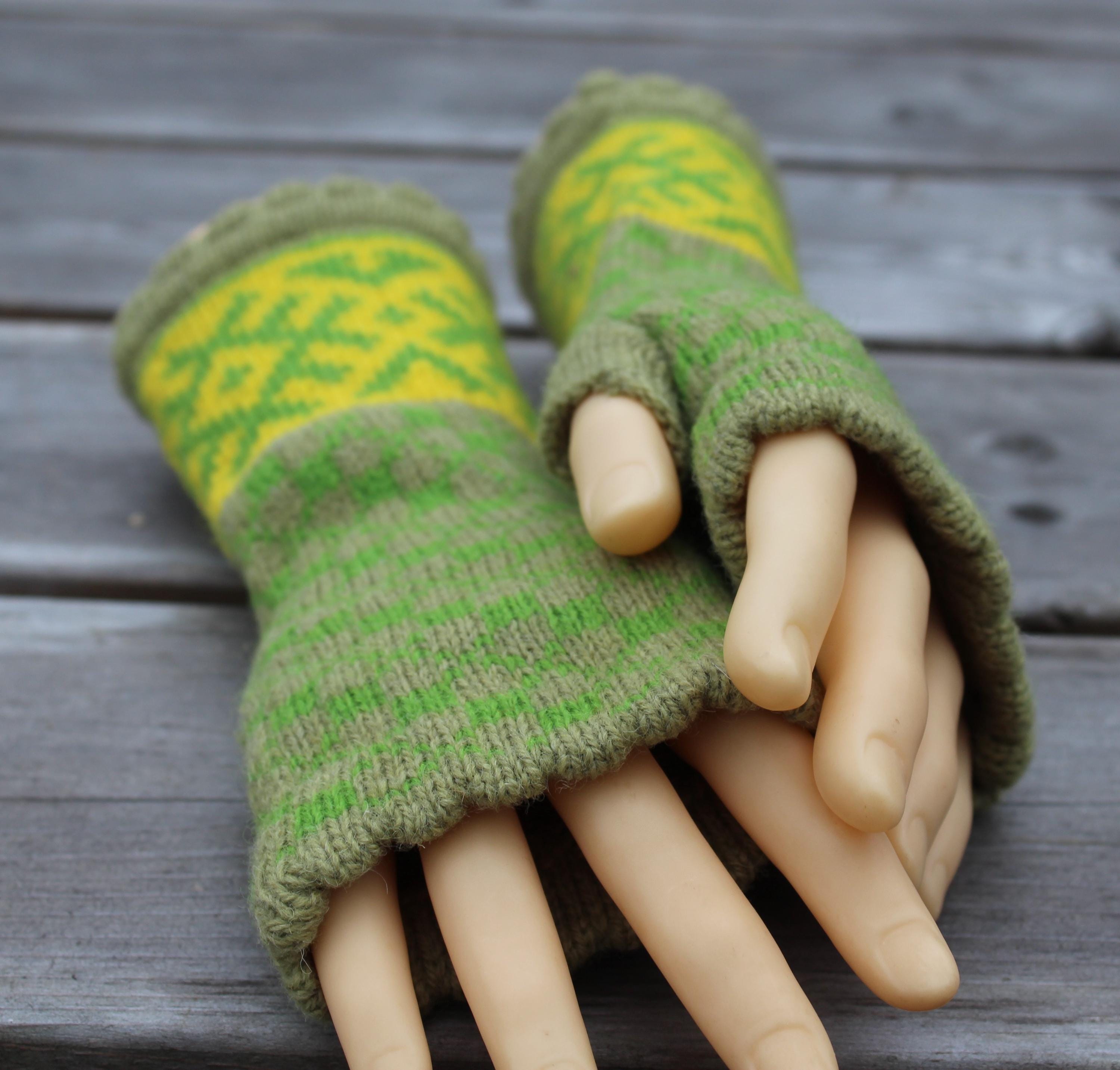 Green and yellow patterned fingerless gloves on a wooden surface