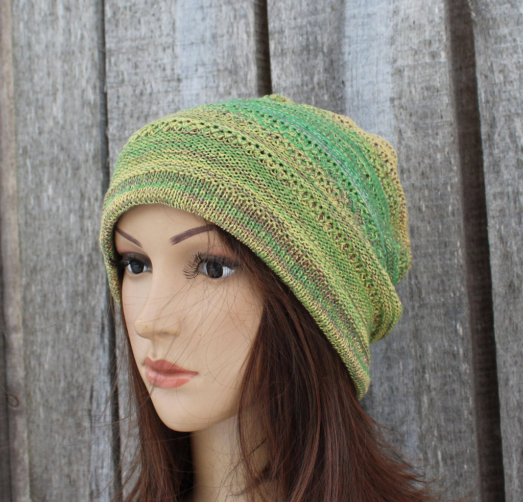 Green knitted hat on a mannequin head against a wooden background